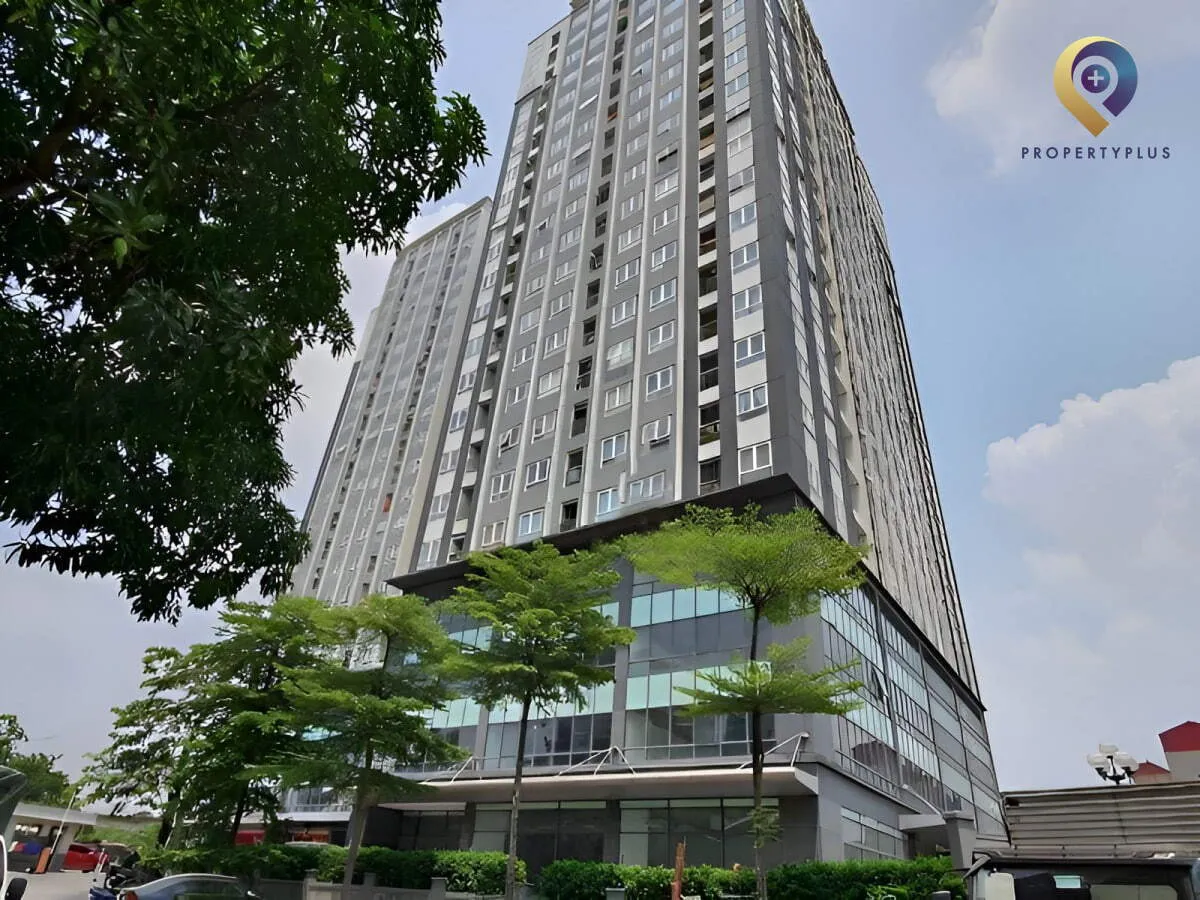 Toàn cảnh tòa nhà UDIC-Riverside nhìn từ góc đường với không gian xanh phía trước.